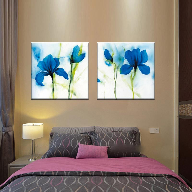 Blue Flower, Abstract Accents - 2 Piece canvas wall art featuring vibrant watercolor blue iris flowers with green stems on white background, displayed as two matching panels above a bedroom setting
