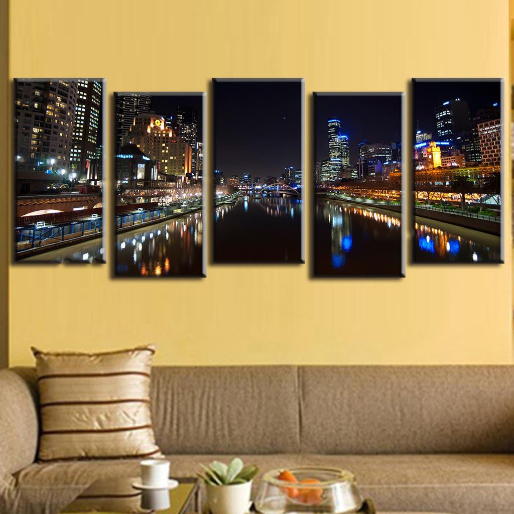 Cityscape at Night with Reflection - 5-panel canvas wall art showing illuminated urban skyline with vibrant city lights reflecting on calm river waters, featuring modern skyscrapers and waterfront architecture in dramatic nighttime setting