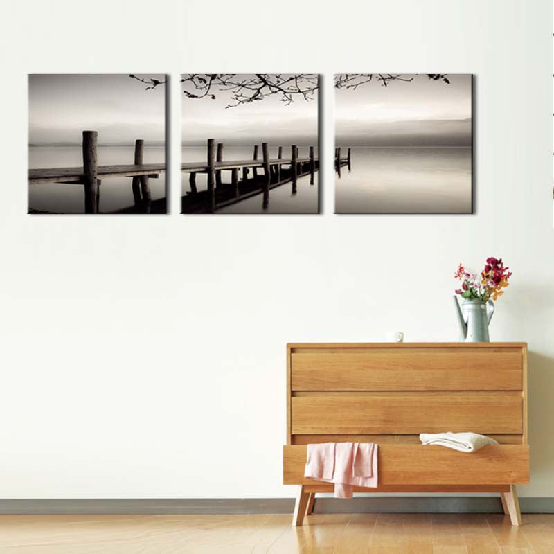 Dock and Gray River - Serene black and white triptych canvas art featuring a misty wooden pier extending into calm waters with overhanging tree branches, creating a minimalist waterfront landscape